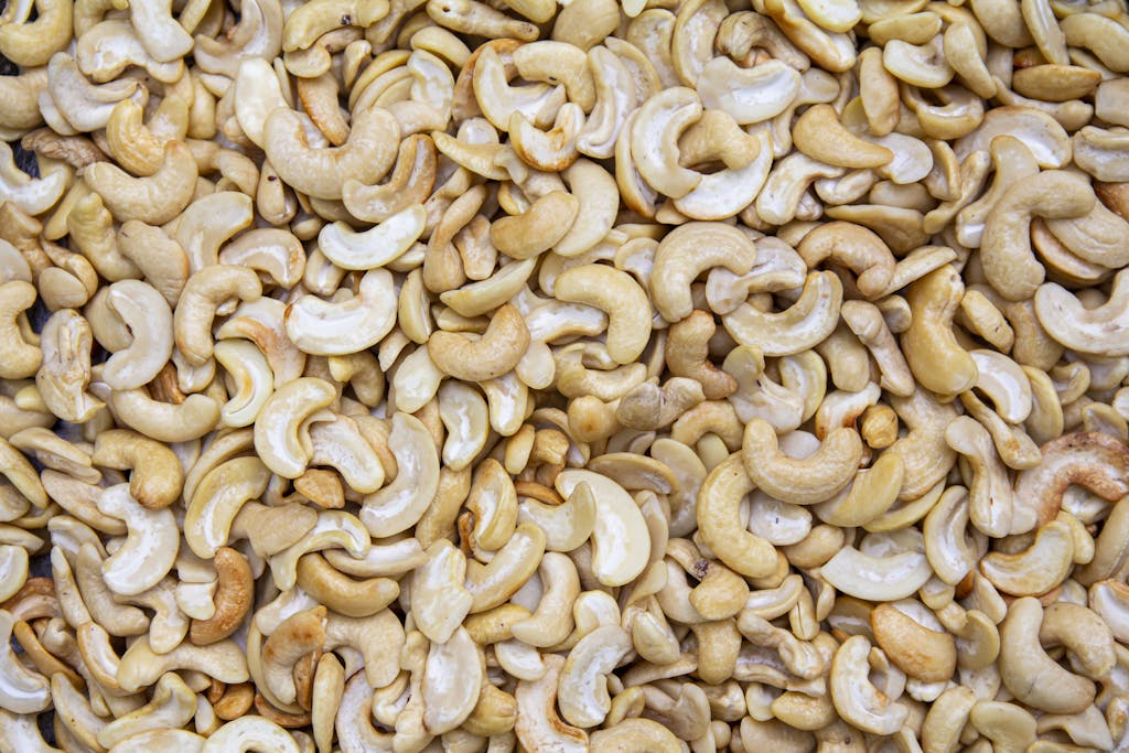 A detailed close-up of roasted cashew nuts creating a textured, appetizing backdrop.